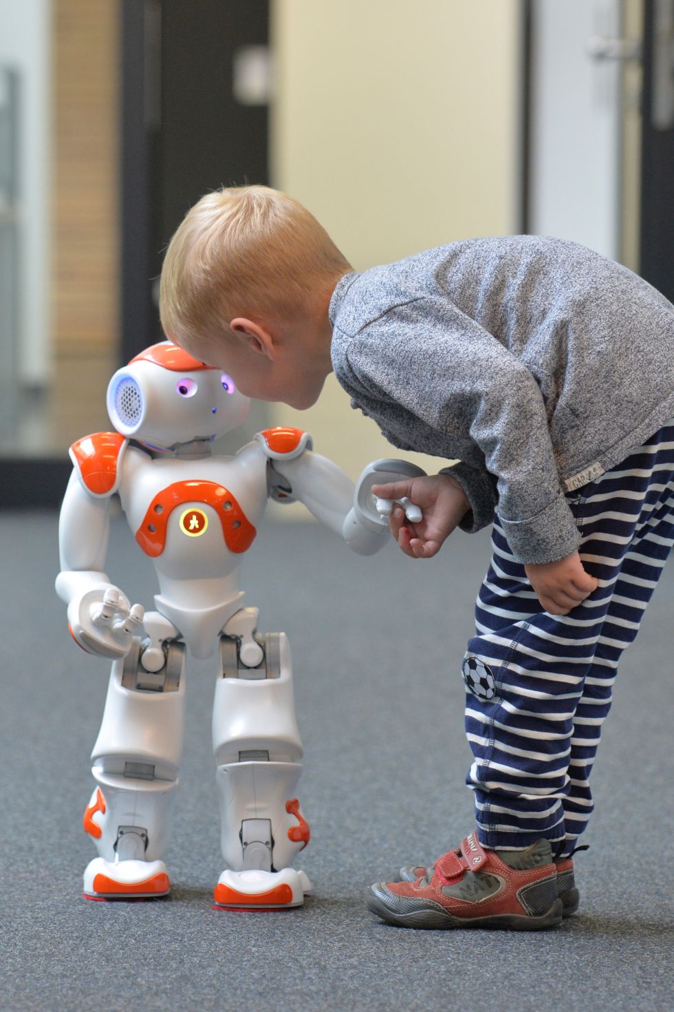 Menino tenta se comunicar com o robô Neo.